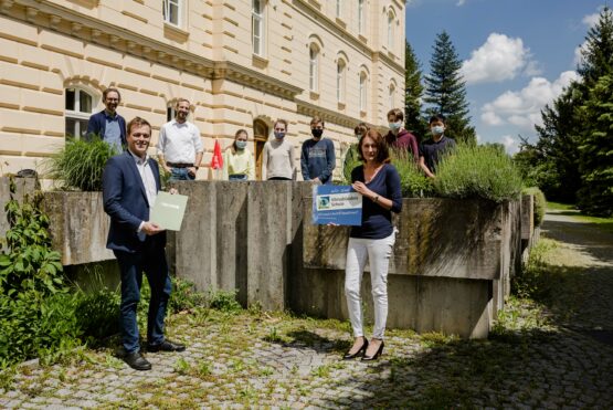 Klimalandesrat Stefan Kaineder überreicht mit Norbert Rainer (Regionalstellenleiter Klimabündnis OÖ) Urkunde und Klimabündnis-Schultafel an Schulprojektleiterin Sabine Weidinger und Schulleiter Wolfgang Kurz