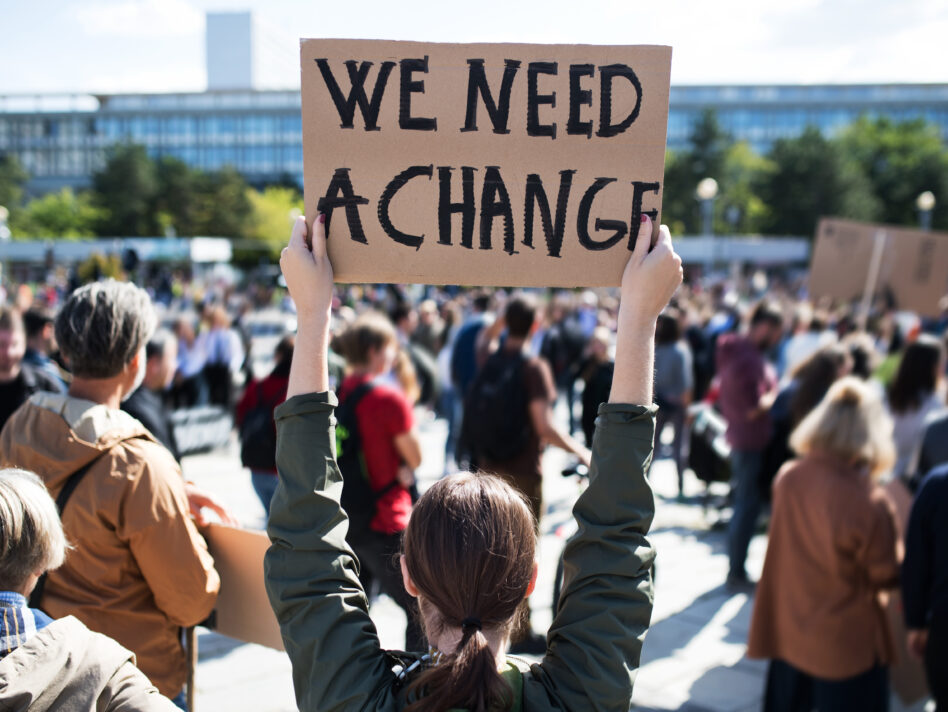 A rear view of people with placards and posters on global strike for climate change.