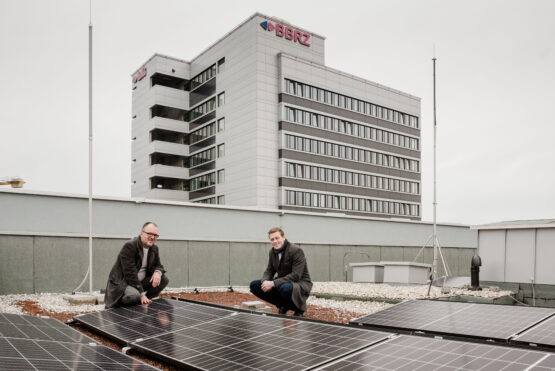 Klimalandesrat Stefan Kaineder mit dem Geschäftsführer des BFI Oberösterreich Dr. Christian Jungwirth vor dem neuen Sonnenkraftwerk am Dach des Linzer BFI