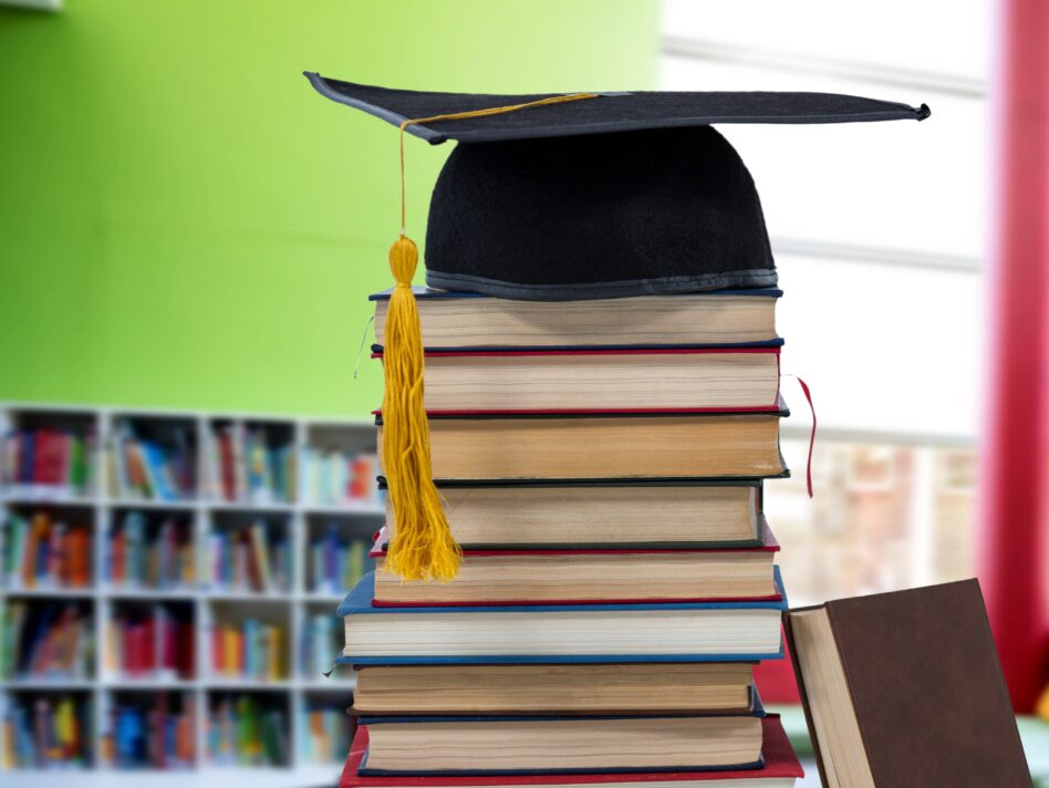 Digital composite of Books and graduation hat in education library