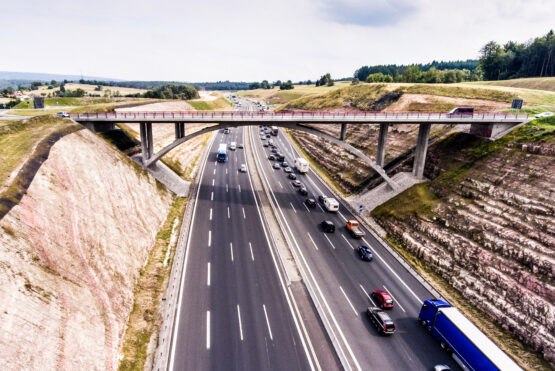 Aerial view of highway full of cars and trucks, traffic jam in the middle of green forest, Netherlands