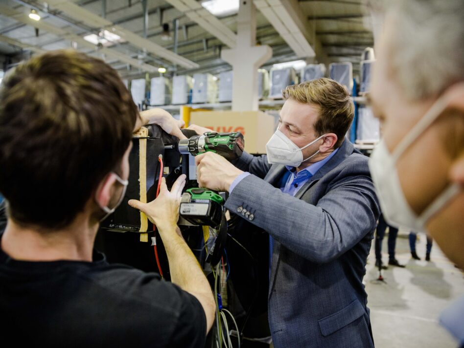 Landesrat Stefan Kaineder mit Akkuschrauber bei Firma Guntamatic