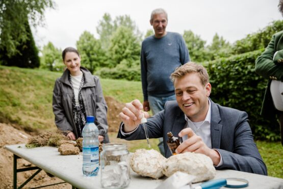 Klima-Landesrat Stefan Kaineder macht eine Kalkprobe mit Salzsäure am Bodenfest