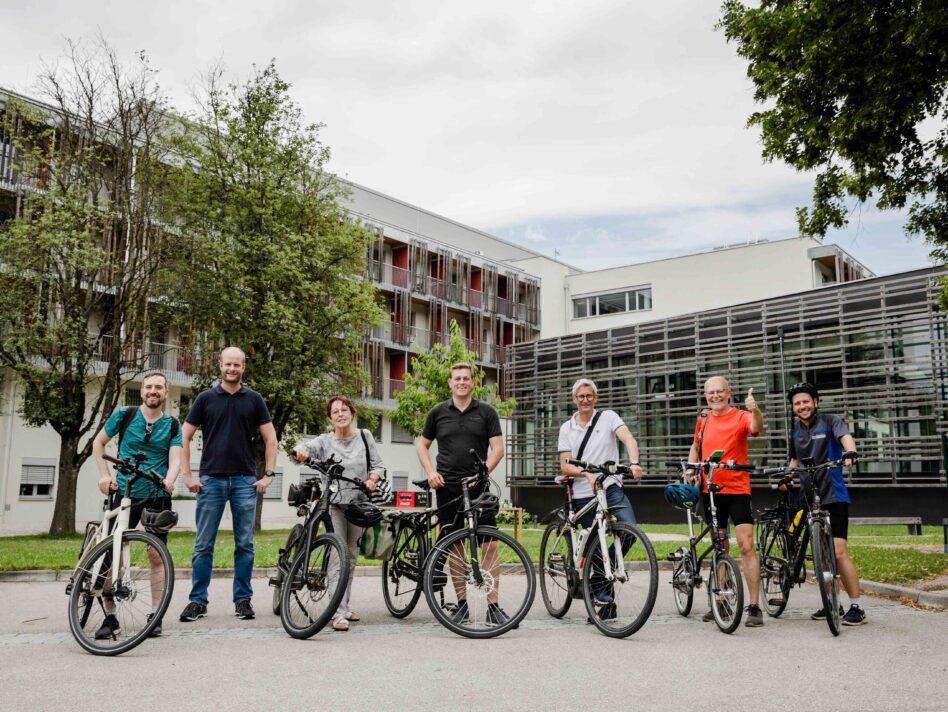 Markus Lang (passathon), Oliver Zörrer (Verwalter Eisenbahnerheim), Christine Gruber (Grüne Bad Schallerbach), Klima-Landesrat Stefan Kaineder, Bürgermeister Markus Brandlmayr (Bad Schallerbach), Günter Lang (passathon) und Maximilian Lang (passathon) vor der mustersanierten Gesundheitseinrichtung der Versicherungsanstalt für Eisenbahn und Bergbau in Bad Schallerbach