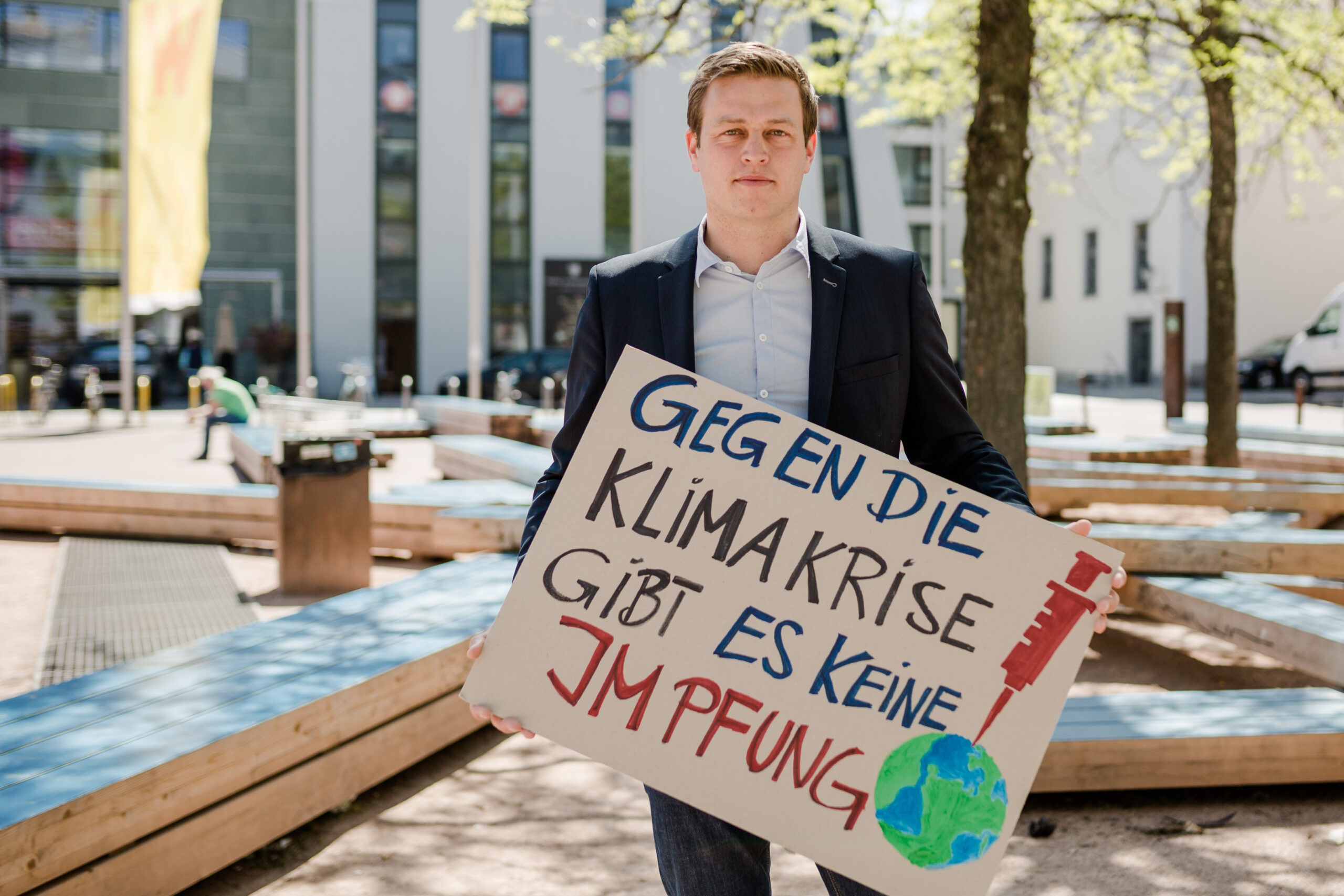 Stefan Kaineder mit Schild "Gegen die Klimakrise gibt es keine Impfung"