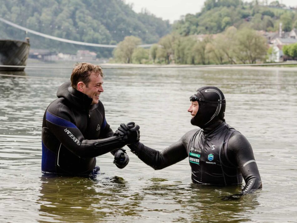 Umwelt- und Klima-Landesrat Stefan Kaineder  beim Handshake mit dem „schwimmenden Professor“ Prof. Dr. Andreas Fath.