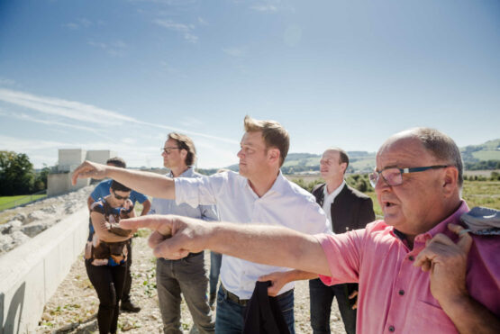 Umwelt- und Klima-Landesrat Stefan Kaineder mit den Bürgermeistern der Gemeinden Nußbach und Wartberg an der Krems und Wasserbauexpert/innen des Landes bei der Besichtigung der Baustelle des größten Rückhaltebeckens in Österreich in Krems-Au