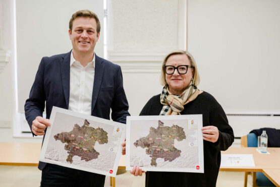 Umwelt- und Klima-Landesrat Stefan Kaineder und Gudrun Achleitner-Kastner mit der Karte der sanierten oder gesicherten Altlasten in Oberösterreich