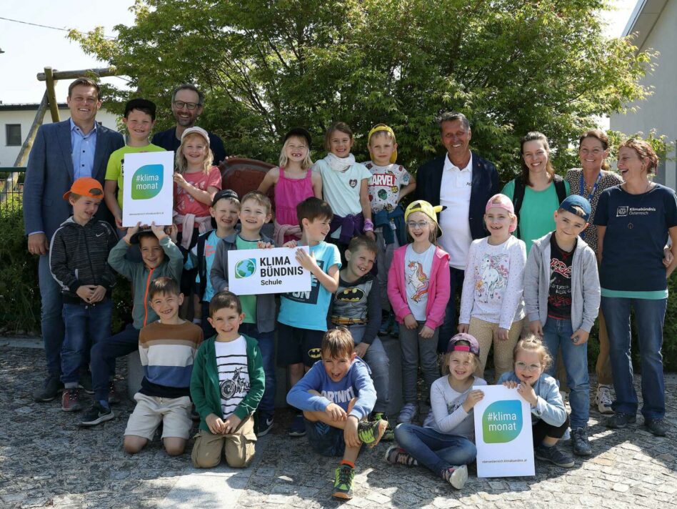 Umwelt- und Klima-Landesrat Stefan Kaineder mit den erwartungsvollen Schüler/innen der Grundstufe 1 der Volksschule Atzbach, Norbert Rainer Klimabündnis Oberösterreich, Bgm. Berthold Reiter, Klassenlehrerin Elisabeth Hörmann, Dir.in Daniela Mühlleitner und Workshopleiterin Bettina Stock kurz vor dem Start in den Klimabündnis Workshop in einem nahegelegenen Waldstück.