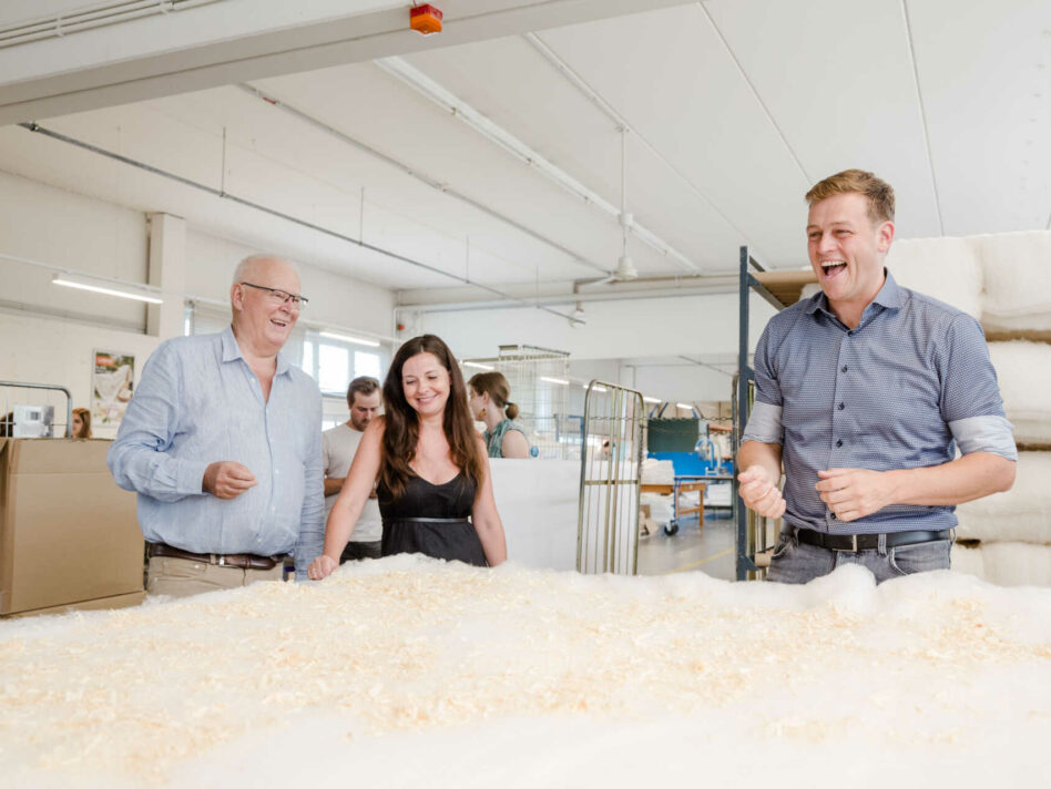 Betten Reiter Geschäftsführer Peter Hildebrand, Veronika Bohrn Mena (Initiative Lieferkettengesetz) und Umwelt- und Klima-Landesrat Stefan Kaineder bei der Produktion einer Zirbendecke in der Manufaktur von Betten Reiter in Leonding